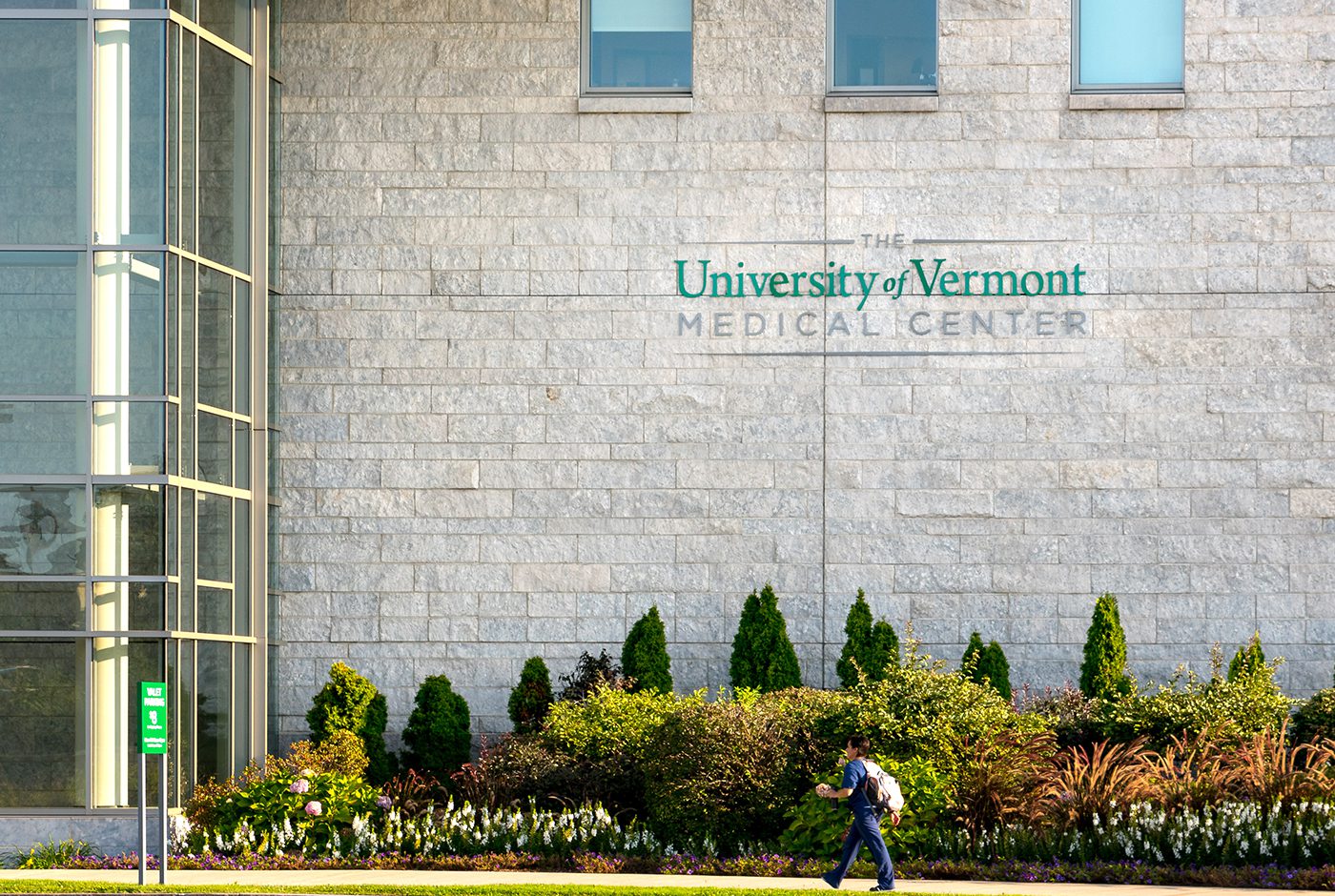 A man walks past the University of Vermont health network building